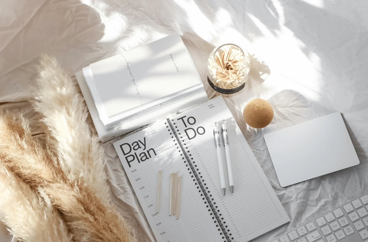 a paper planner with pencils on top.